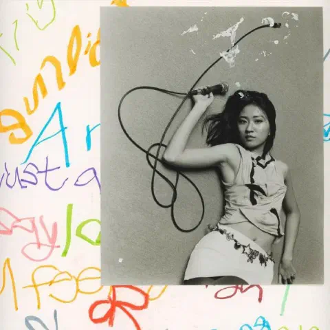 A square album cover for 9m88 Radio by 9m88. The album cover shows a black-and-white photograph of the artist holding a wired microphone, its cable looping across a grey wall. The photograph is set against a white background covered in colourful handwritten lettering.