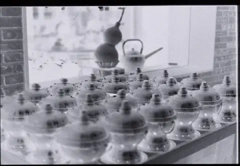 a photo of a negative showing a table covered in urns