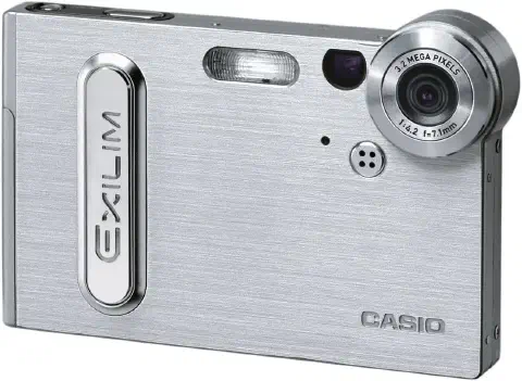 A product shot of the Casio EXILIM EX-S3 digital camera. The camera is standing upright the lense facing towards the viewer. To the left of the lens, a small view finder and a flash. Just below the lens and slightly to the left, four tiny microphone holes. The body of the camera is finished in a brushed metal effect.