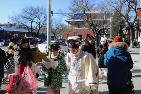 A photo of people dressed up in traditional costume heading towards the Forbidden City in China.