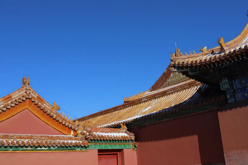 Looking over the roofs of the forbidden city. The image captures the turned up corner of the closes roof, small figures of animals visible on the resulting ridge.