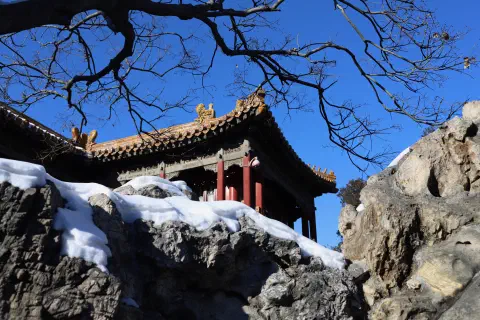 Snowy covered rocks obscure the base of a temple inside the Forbidden City in Beijing.