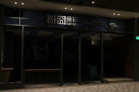 The black, empty shell of an old retail unit. The words 'fun joy' can be seen above the entrance.