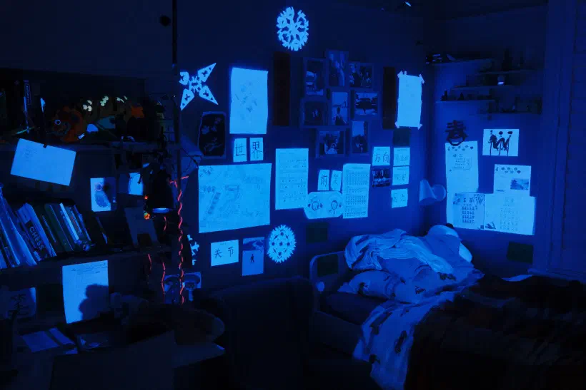 A child's bedroom. Many of the things stuck to the wall glow when lit with UV light.