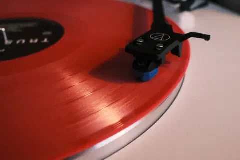 A close-up of a record player. The stylus rests on the record.