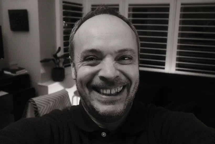 A black and white selfie of someone smiling.