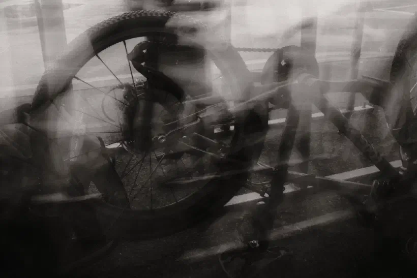 A black and white photo of a bike resting on its seat. The image is blurred as if taken in low light.