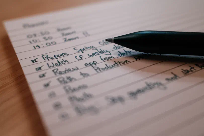 A close up photo of a pen resting on lined paper.