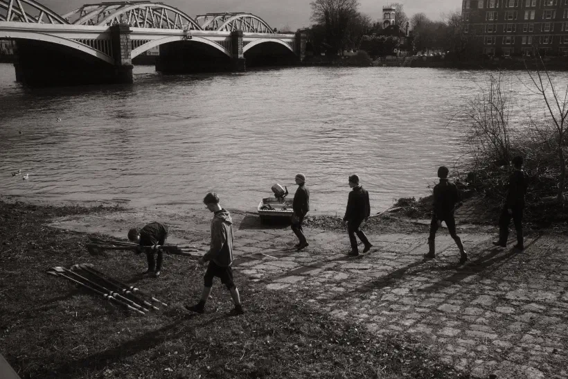 black and white photo of rowers collecting their oars on a slipway near Barnes Bridge