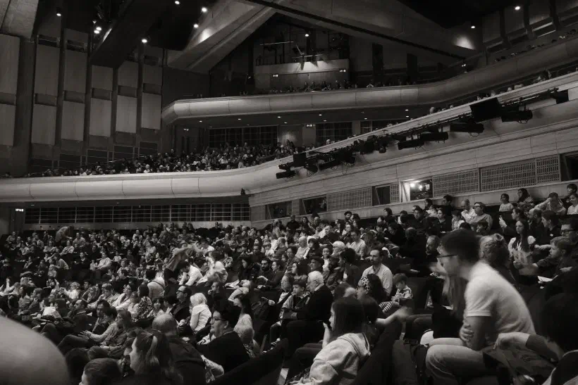 A black and white photo of the audience in the Barbican Concert Hall.