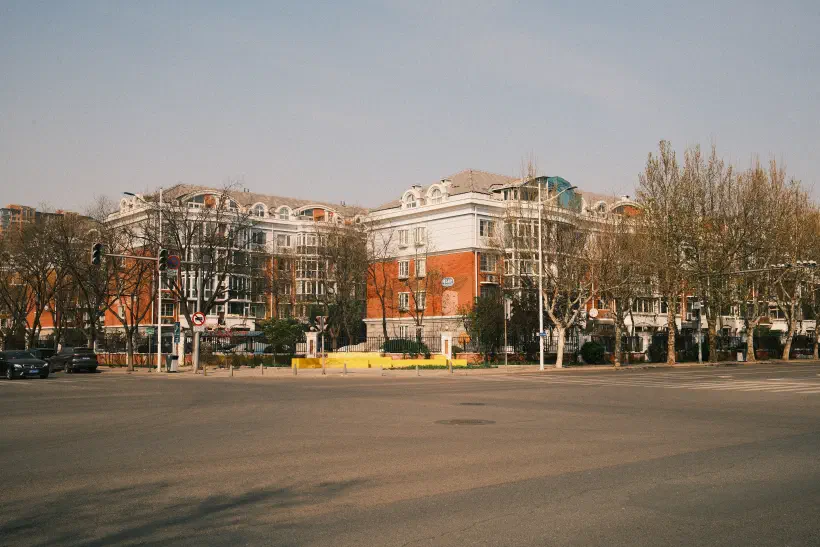 an expansive cross roads, free from traffic, looking over to residential compound