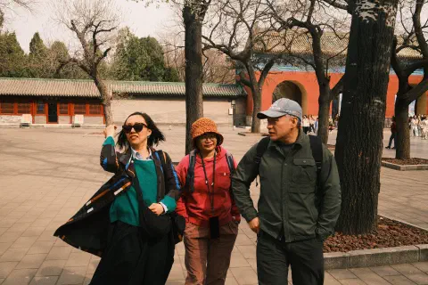 three people walking along talkig in the temple of heaven