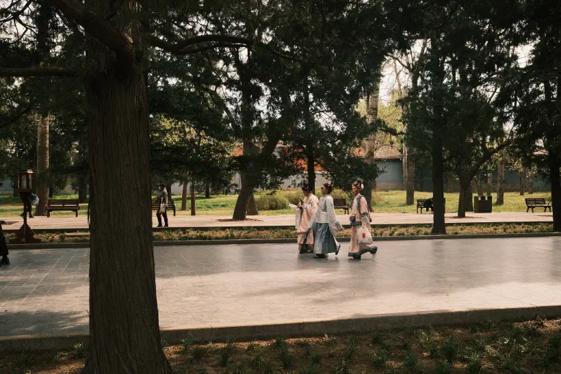 three girls in traditional costume walk through the temple of heaven