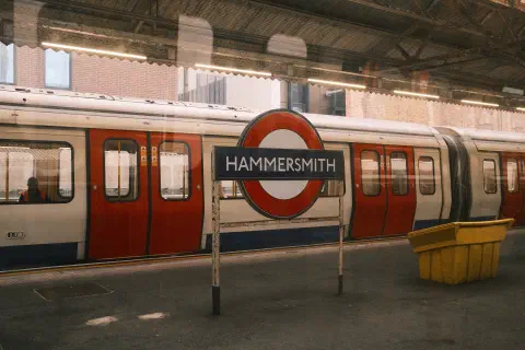 a photo of a hammersmith and city line train standing on the platform at hammersmith