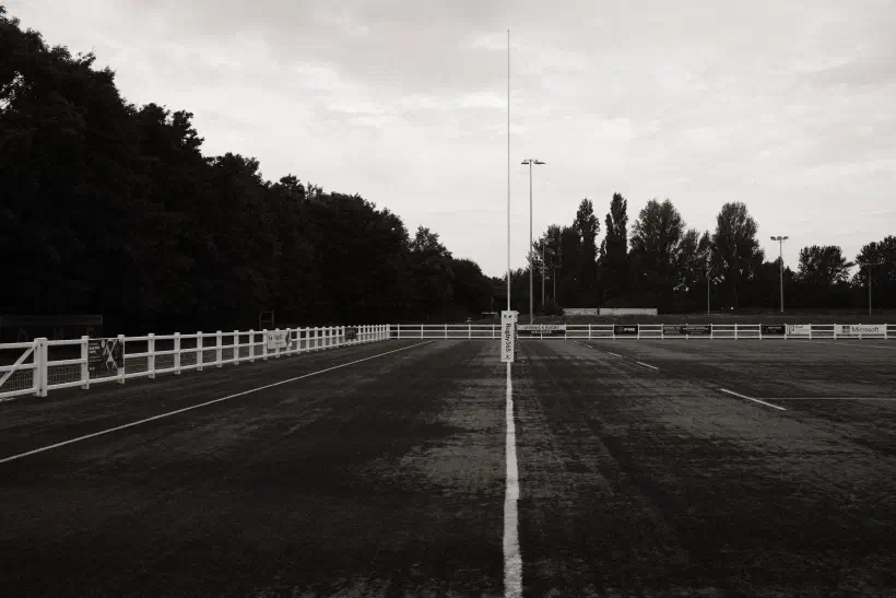 A black and white photo looking along the try-line of a rugby pitch