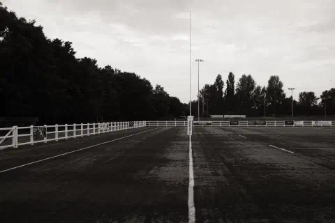 A black and white photo looking along the try-line of a rugby pitch