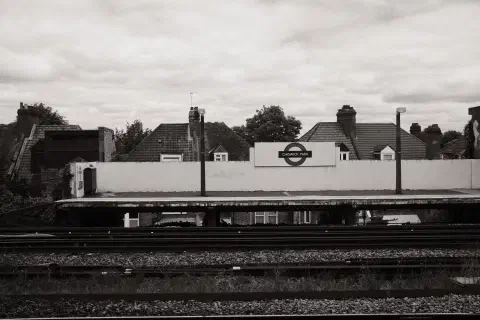 A black and white photo of a London Underground station. This station is above ground. The station name is Chiswick Park.