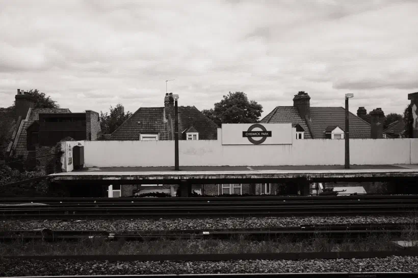A black and white photo of a London Underground station. This station is above ground. The station name is Chiswick Park.